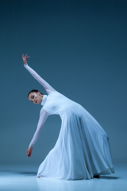 Free photo portrait of the ballerina on blue wall