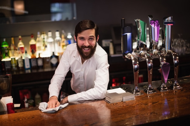 Portrait of bartender cleaning bar counter