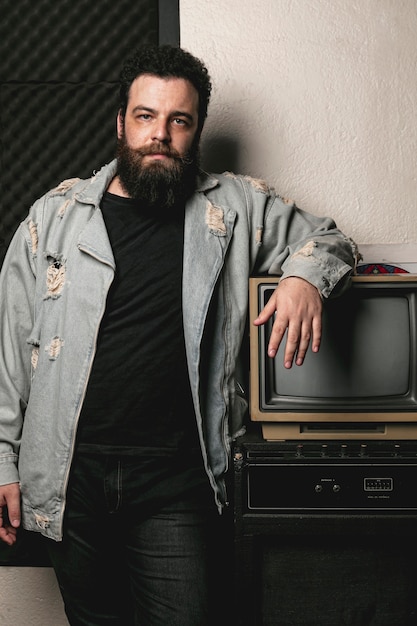 Portrait of beard man next to vintage tv