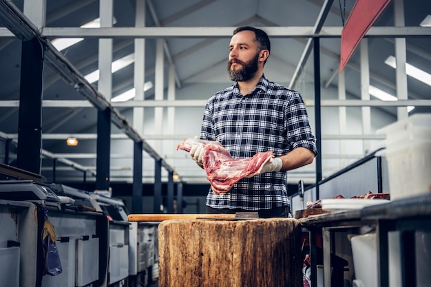 Foto gratuita ritratto di un macellaio barbuto in una macelleria