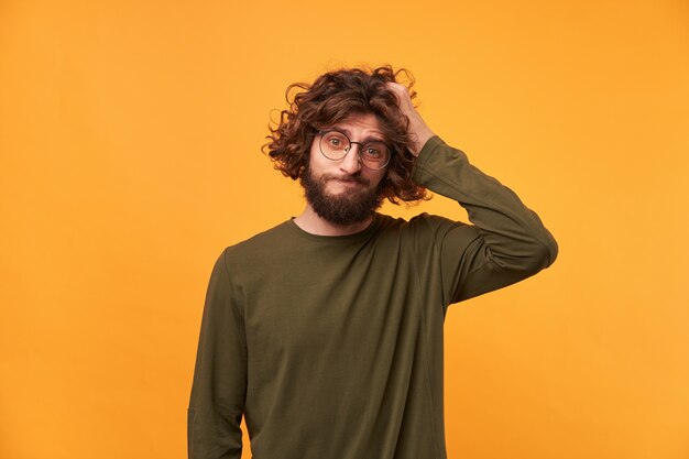 Portrait of bearded casually dressed man in glasses with dark curly hair