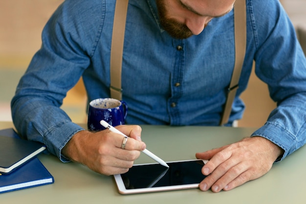 Free photo portrait of bearded man sketching on tablet