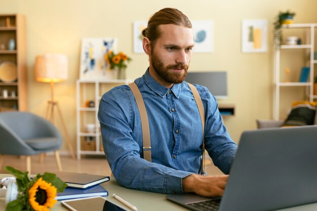 Foto gratuita ritratto dell'uomo barbuto che lavora al computer portatile