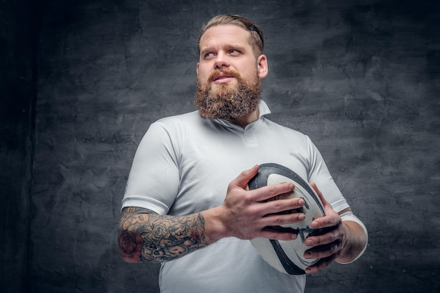 Free photo portrait of bearded rugby player with tattoos on his arms