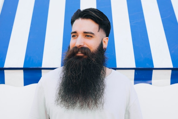 Portrait of a bearded young man standing in front of awning