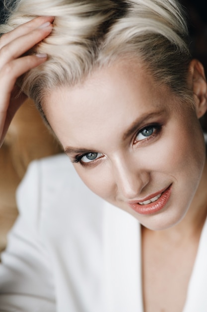 Portrait of beauitful blonde woman with short hair and deep blue eyes