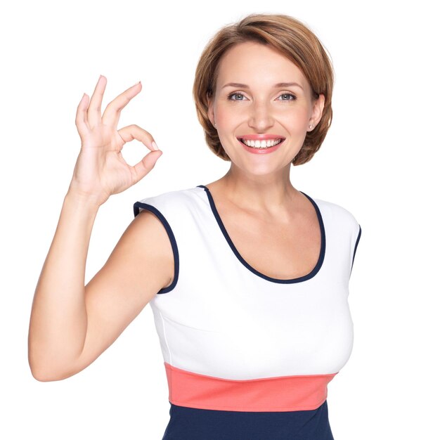 Portrait of a beautiful adult happy woman with ok gesture over white wall