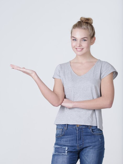 Portrait of a beautiful adult happy woman with presentation gesture over white background