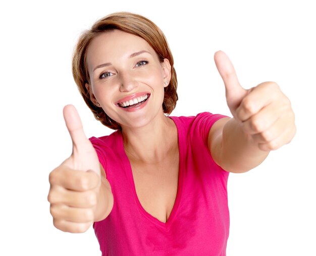 Portrait of a beautiful adult happy woman with thumbs up sign over white wall