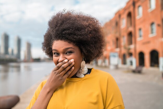 Портрет красивой афро-латинской уверенной женщины, смеющейся на улице. На открытом воздухе. Городская концепция.
