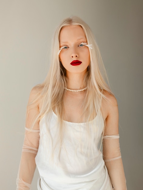 Foto gratuita ritratto di bella donna albina con piume come ciglia