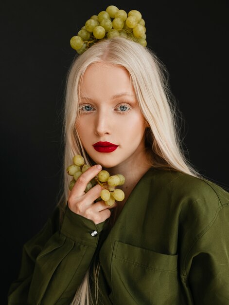 Portrait of beautiful albino woman with grapes