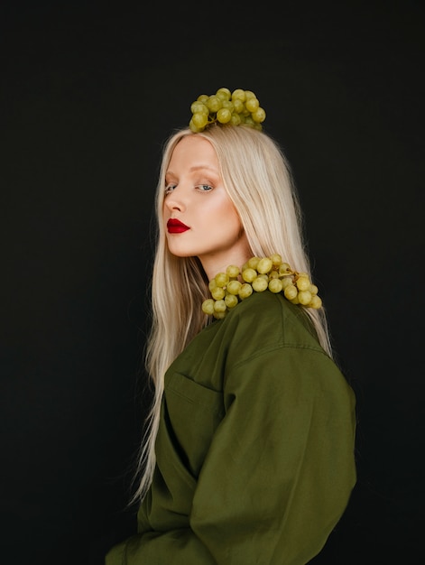 Портрет красивой женщины-альбиноса с виноградом