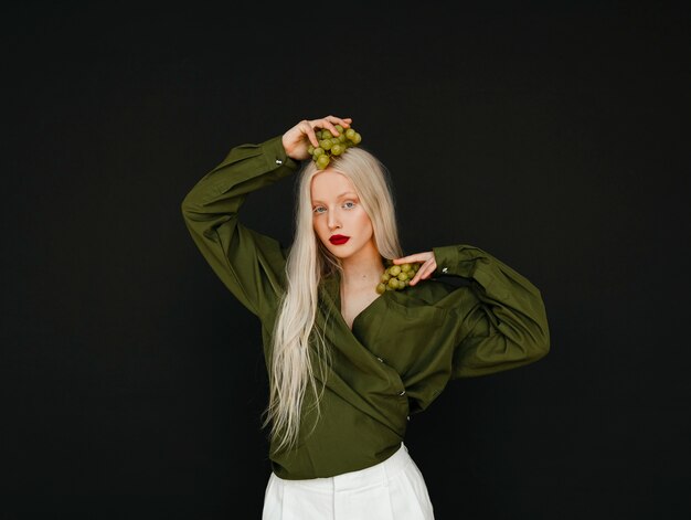 Portrait of beautiful albino woman with grapes