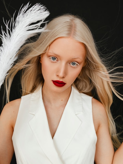 Free photo portrait of beautiful albino woman with white feather