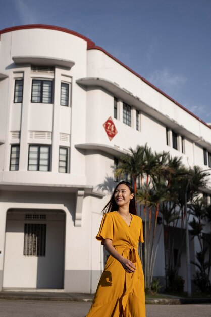 Portrait of beautiful asian woman posing in the city while wearing yellow dress