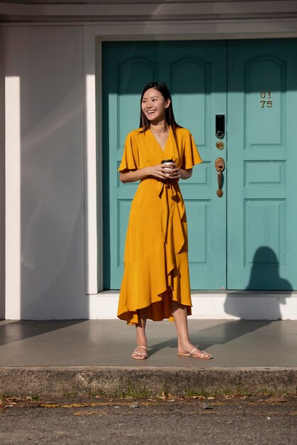 Portrait of beautiful asian woman posing outdoors in the city while having coffee