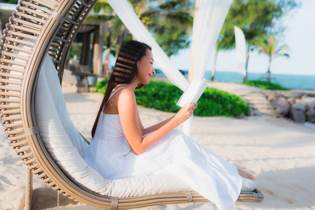 Portrait beautiful asian woman reading book around beach sea ocean