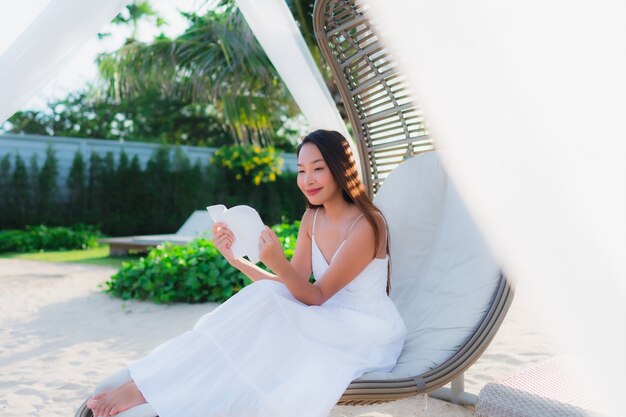 Portrait beautiful asian woman reading book around beach sea ocean