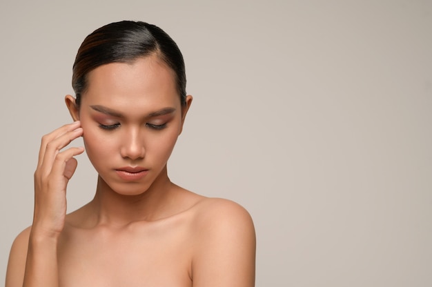 Portrait of beautiful asian woman touches cheek and closed her eyes