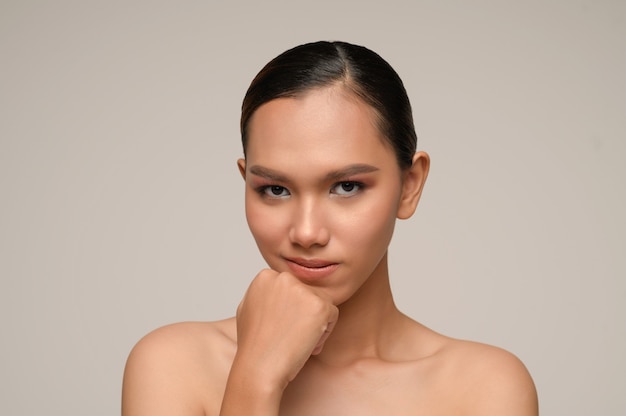 Free photo portrait of beautiful asian woman touches chin and smiles