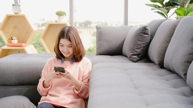 Portrait of beautiful attractive young smiling Asian woman using smartphone