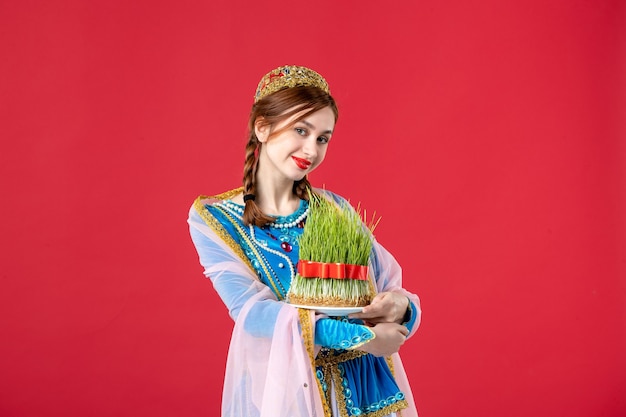 Free photo portrait of beautiful azeri woman in traditional dress with semeni on red