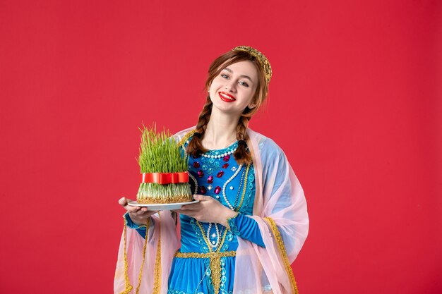 Portrait of beautiful azeri woman in traditional dress with semeni on red