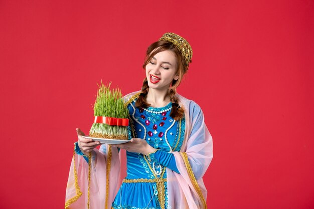 Portrait of beautiful azeri woman in traditional dress with semeni on red