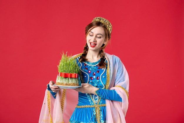 Portrait of beautiful azeri woman in traditional dress with semeni on red