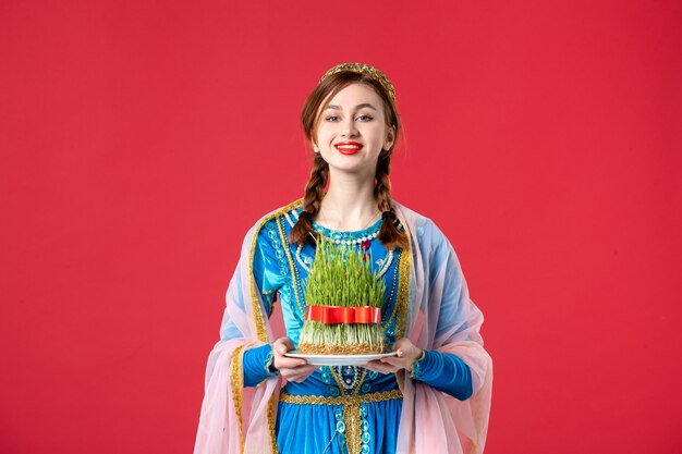 Portrait of beautiful azeri woman in traditional dress with semeni on red