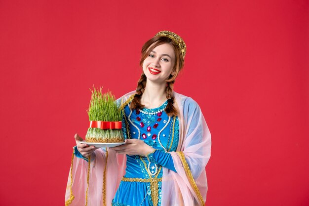 Portrait of beautiful azeri woman in traditional dress with semeni on red