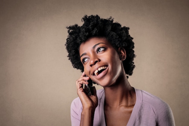 Portrait of a beautiful black female happily talking on her cellohine