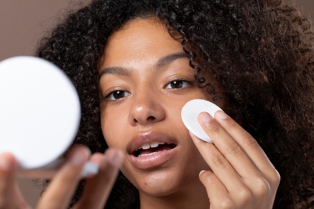 Portrait of beautiful black woman doing her skin care routine