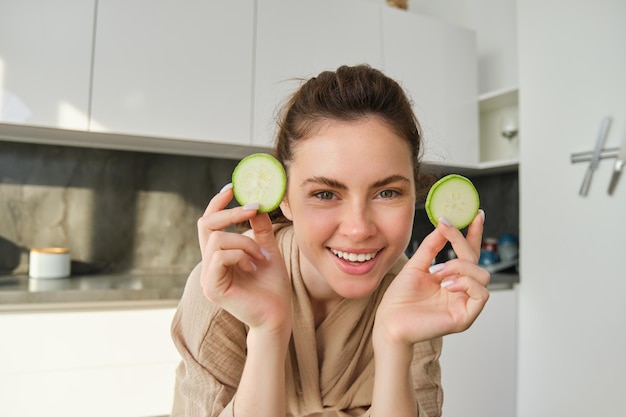 Portrait of beautiful brunette girl cooking in the kitchen posing in bathrobe at home holding