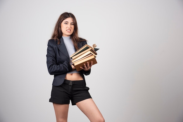 Portrait of beautiful businesswoman holding a stack of books . 