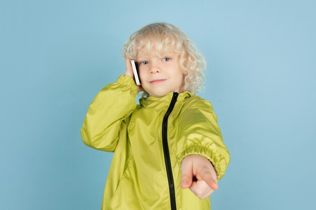 Portrait of beautiful caucasian little boy isolated on blue  wall