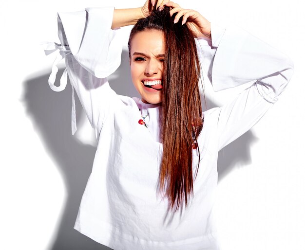 Portrait of beautiful caucasian smiling brunette woman model in white blouse and summer stylish blue jeans with flowers print 