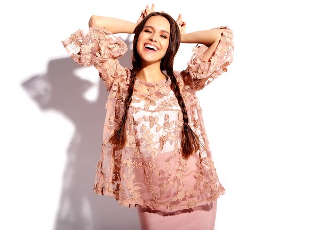 Portrait of beautiful caucasian smiling brunette woman model with double pigtails in bright pink summer stylish clothes