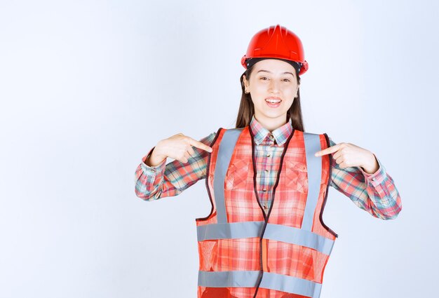 Portrait of beautiful construction worker pointing on white background. 