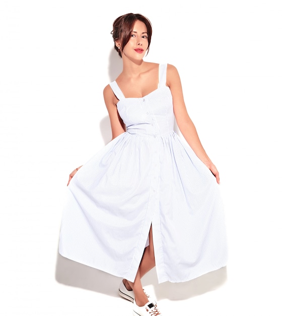 肖像画白で隔離される化粧なしのカジュアルな夏のドレスで美しいかわいいブルネットの女性モデル