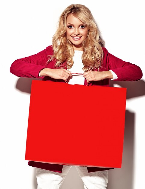 portrait of beautiful cute happy sweet surprised blonde woman girl holding in her hands big shopping bag in hipster red clothes isolated on white