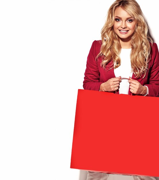 portrait of beautiful cute happy sweet surprised blonde woman girl holding in her hands big shopping bag in hipster red clothes isolated on white