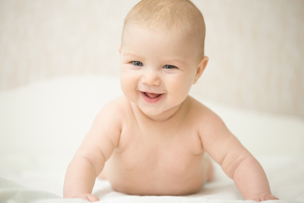 Free photo portrait of a beautiful expressive laughing baby, holds head up