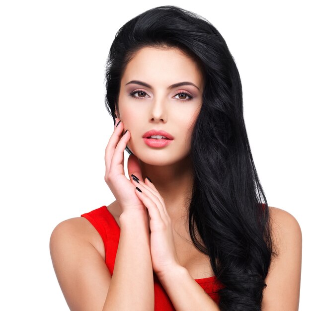 Portrait of beautiful face of an young woman with long brown hair in red dress