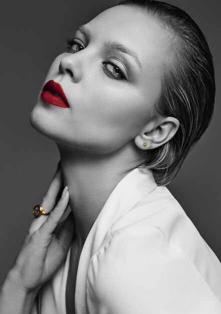 Portrait of beautiful fashion stylish brunette woman model with evening makeup and red lips in white jacket