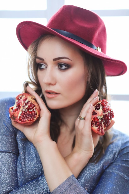Portrait of beautiful fashion woman with pomegranate fruit