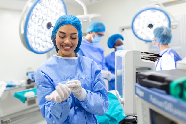수술실에 서 있는 의료용 장갑을 끼고 있는 아름다운 여성 의사 외과 의사의 초상화 현대 수술실의 외과의사