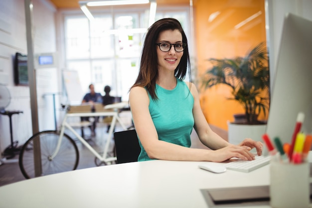 Foto gratuita ritratto di bella femmina esecutiva di lavoro alla sua scrivania