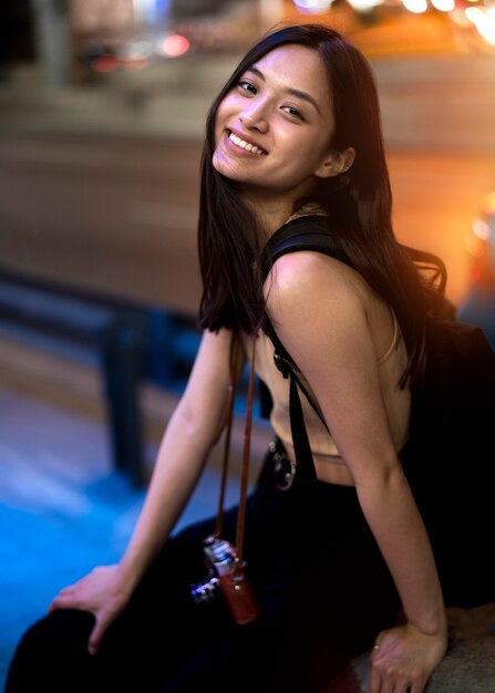 Portrait of beautiful female photographer in the city at night